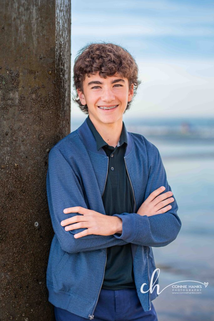 Family photos at Scripps Pier, La Jolla Beach. Stylized family with toes in sand at pier and cliffs.