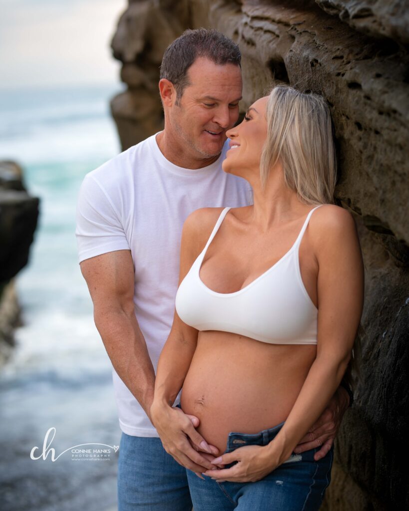 Maternity photos at Windansea Beach, La Jolla. Couple along cliffs at beach.