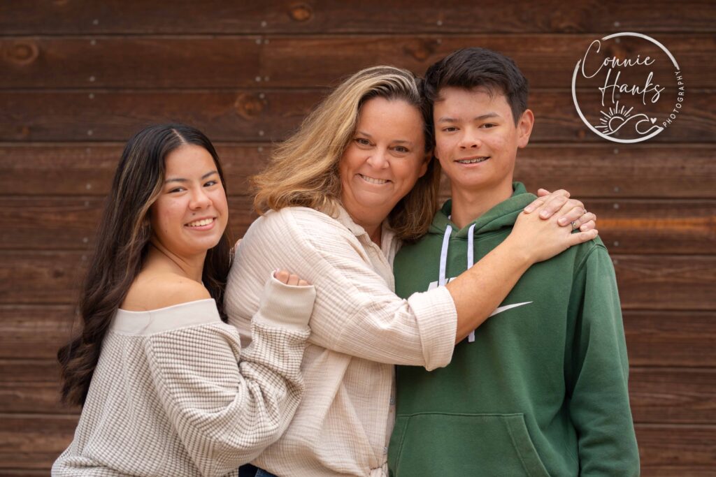 Family photos at Penasquitos Canyon, San Diego, California. Family with teens in wooded tree area, pepper trees, cactus garden, white fencing and rustic vibes.