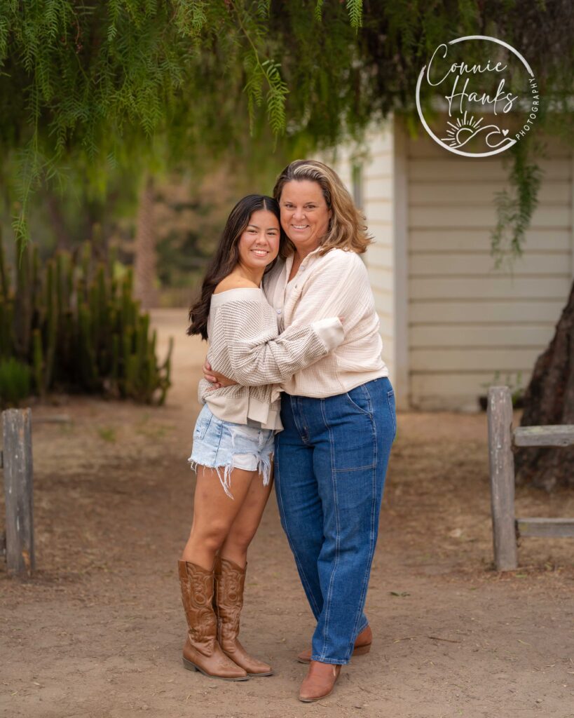Family photos at Penasquitos Canyon, San Diego, California. Family with teens in wooded tree area, pepper trees, cactus garden, white fencing and rustic vibes.