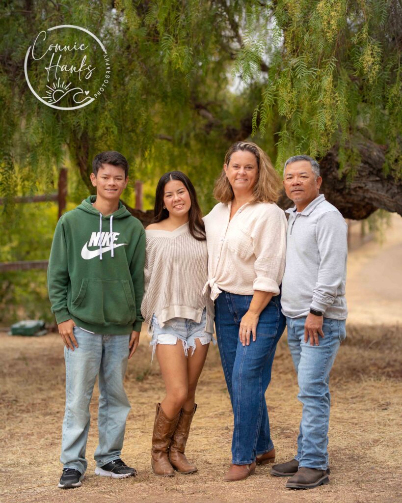 Family photos at Penasquitos Canyon, San Diego, California. Family with teens in wooded tree area, pepper trees, cactus garden, white fencing and rustic vibes.