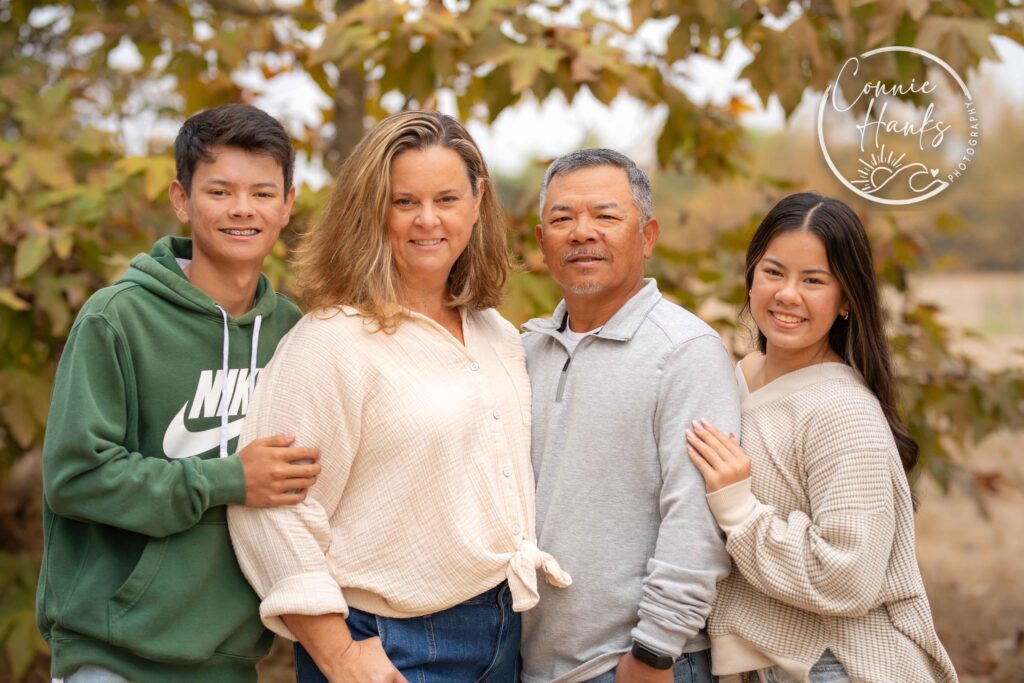 Family photos at Penasquitos Canyon, San Diego, California. Family with teens in wooded tree area, pepper trees, cactus garden, white fencing and rustic vibes.
