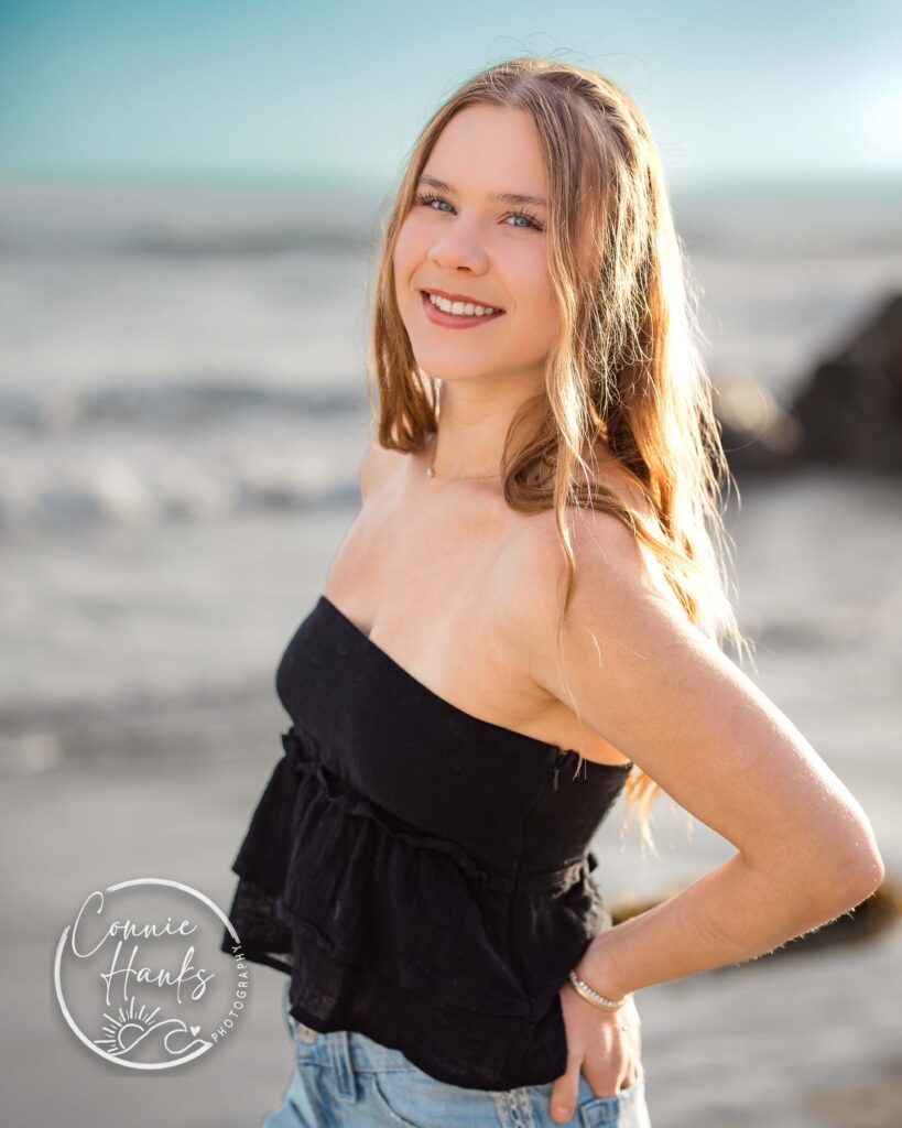 Senior photos at Coronado. Girl standing with beach in background.